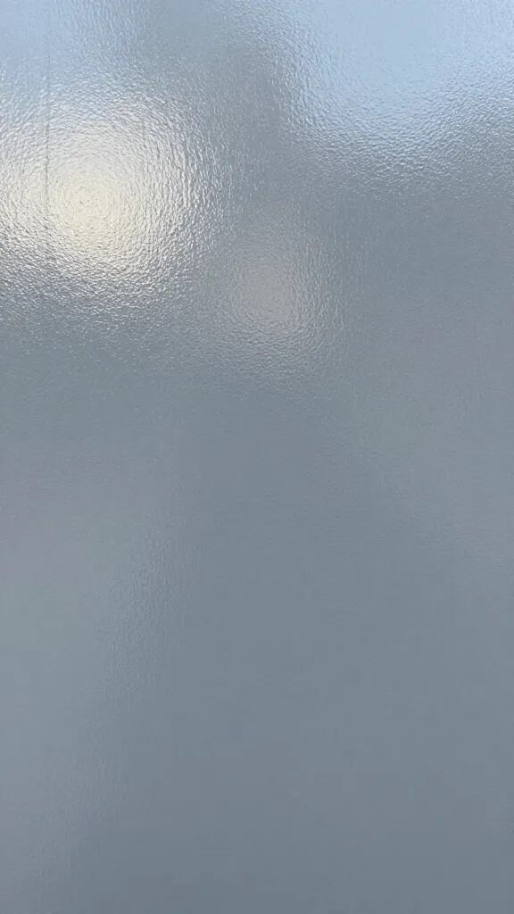Closeup of greige-painted surface reflecting cool daylight