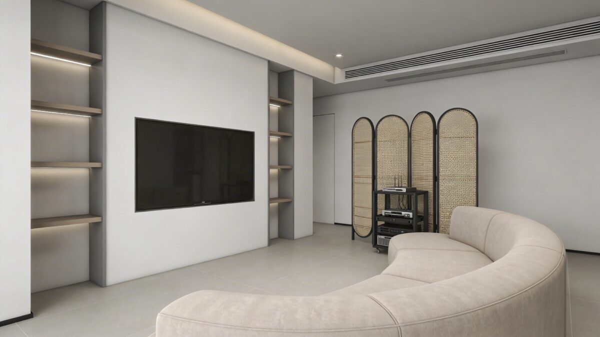 A minimalist layout: slim shelving unit flanking a flat-screen TV, a curved corner sofa facing the screen, and a decorative screen or woven baskets nearby to conceal tech when not in use.
