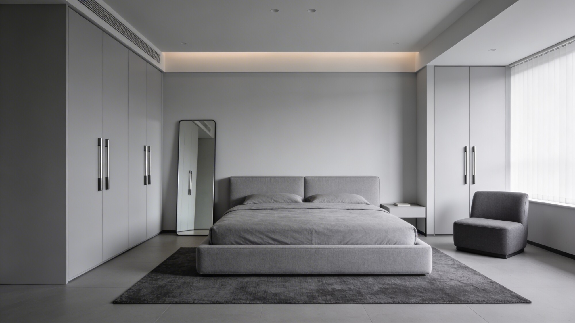 A chic, clutter-free bedroom in a monochrome palette: floating wardrobe doors, a low-profile bed with a light upholstered headboard, a slim mirror to visually expand space, and a small rug anchoring the seating corner.